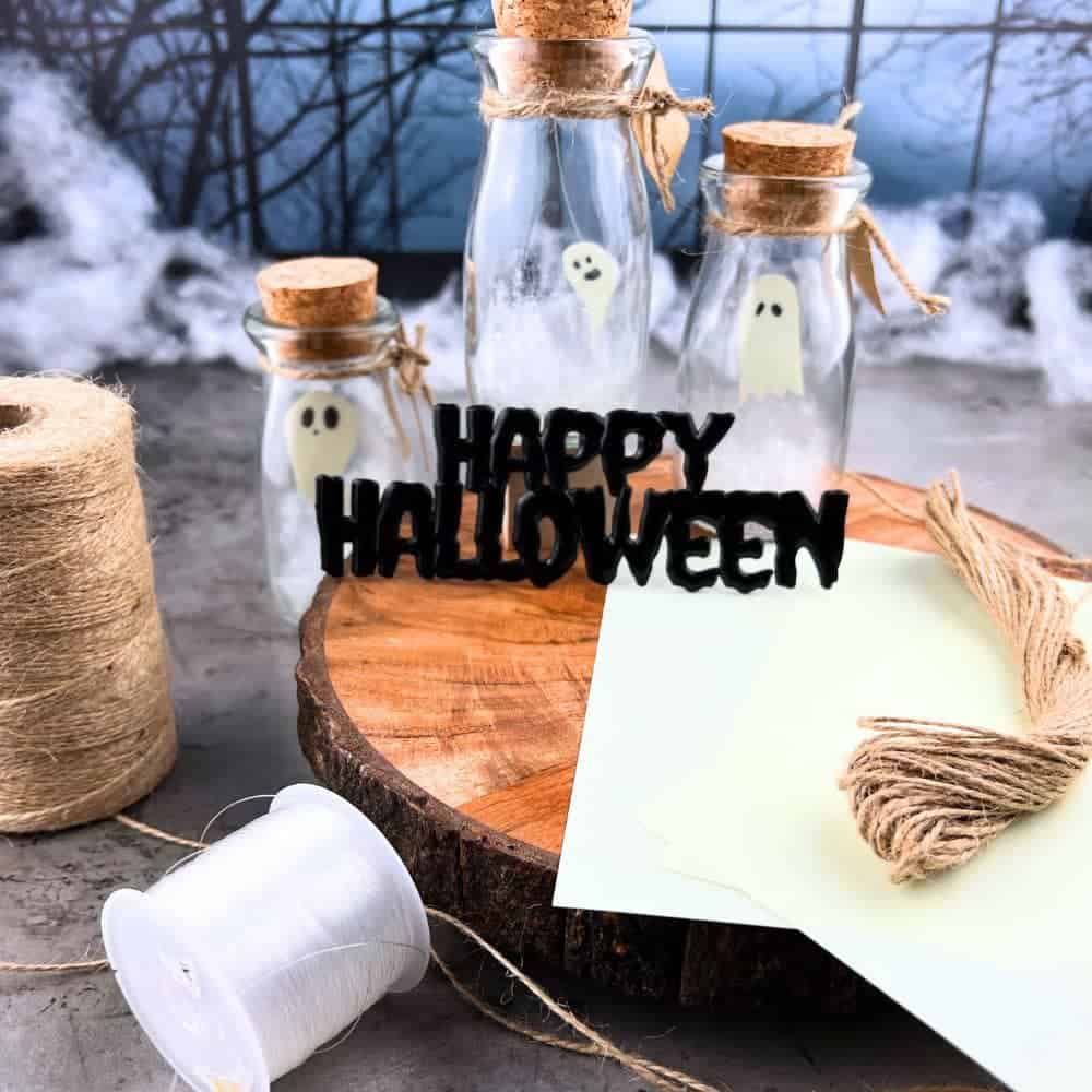 Spirit Jars With Glow In The Dark Ghosts sitting in front of a spooky Halloween moon window