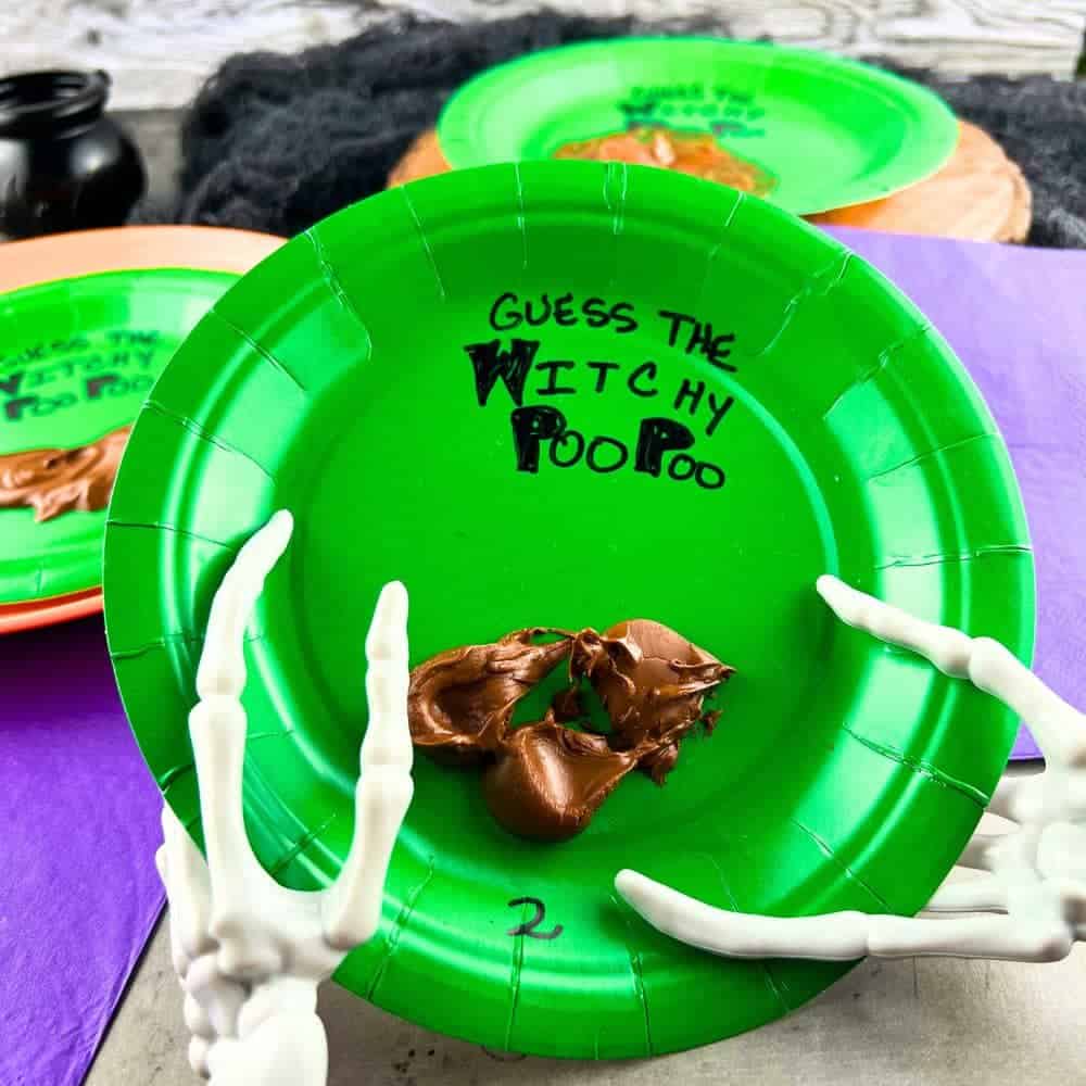 Halloween Party Ideas For Kids (Funny Halloween Candy Game) - green paper plate with melted candy bars held by skeleton hands