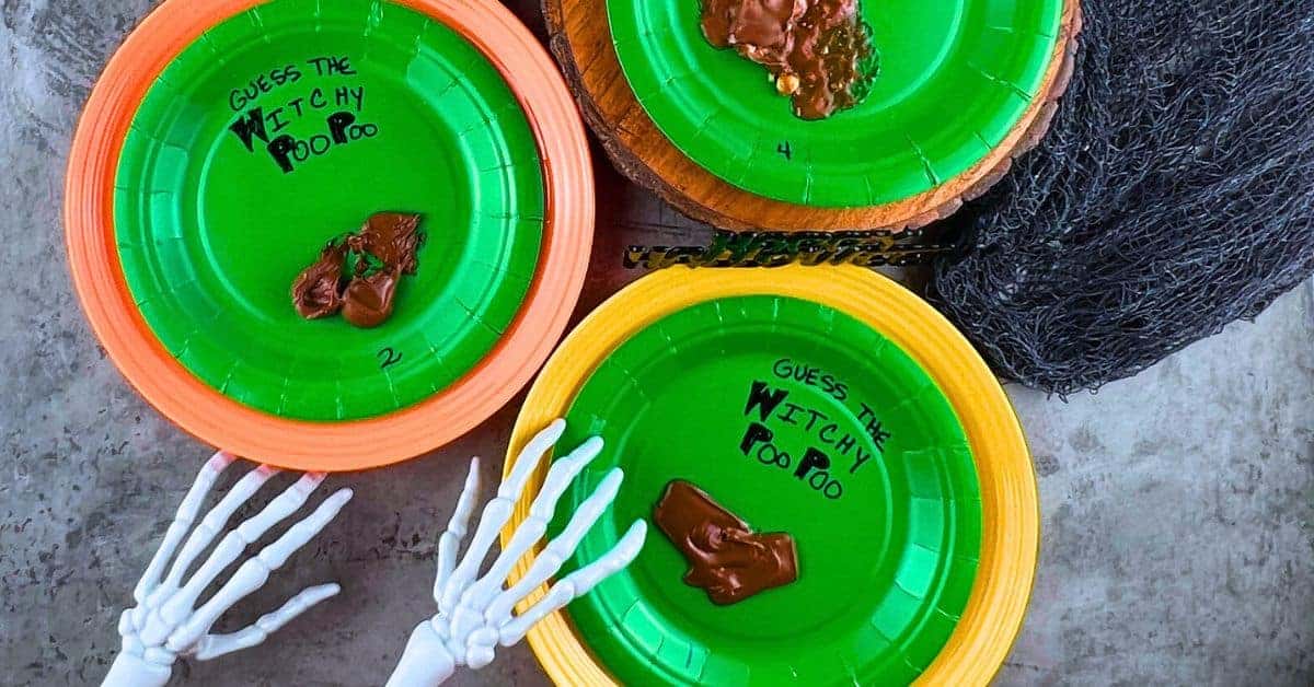 Witchy Poo Poo Hysterical Halloween Game For Family And Kids - paper plates with melted candy bar game on Halloween table with skeleton hands reaching in