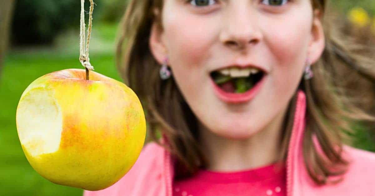 Apple On A String Game For Kids girl laughing playing bobbing apple string game
