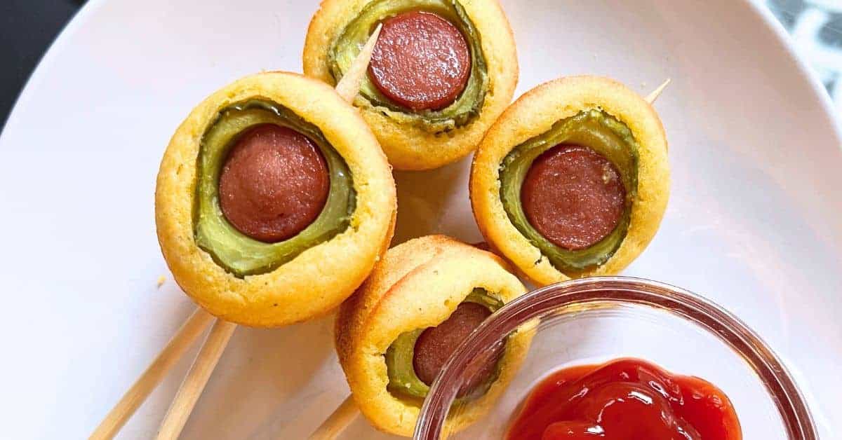 Pickle Corn Dog Bites Recipe (pickle stuffed corn dog) on a white plate with ketchup dipping sauce