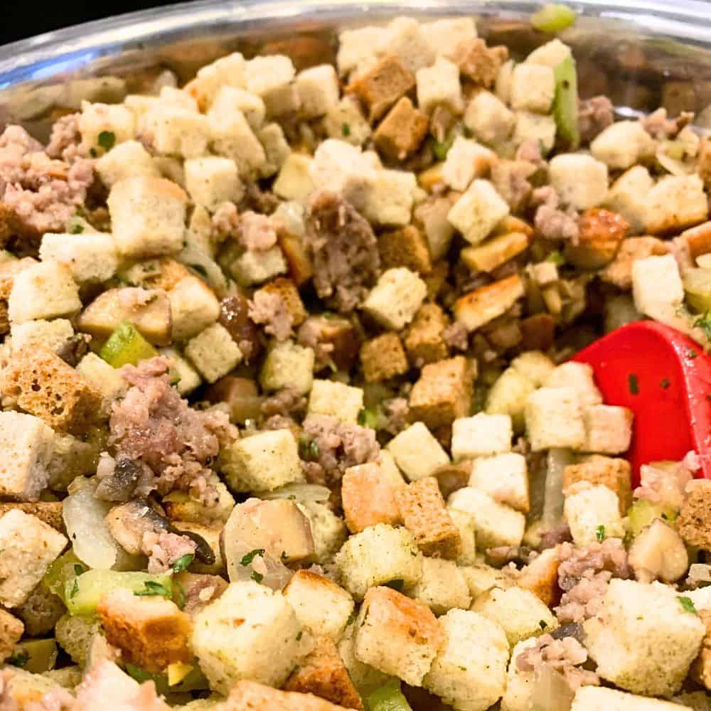 Prepare Bread Cubes For Dressing Recipe - seasoning stuffing cubes in bowl for Thanksgiving dressing recipe