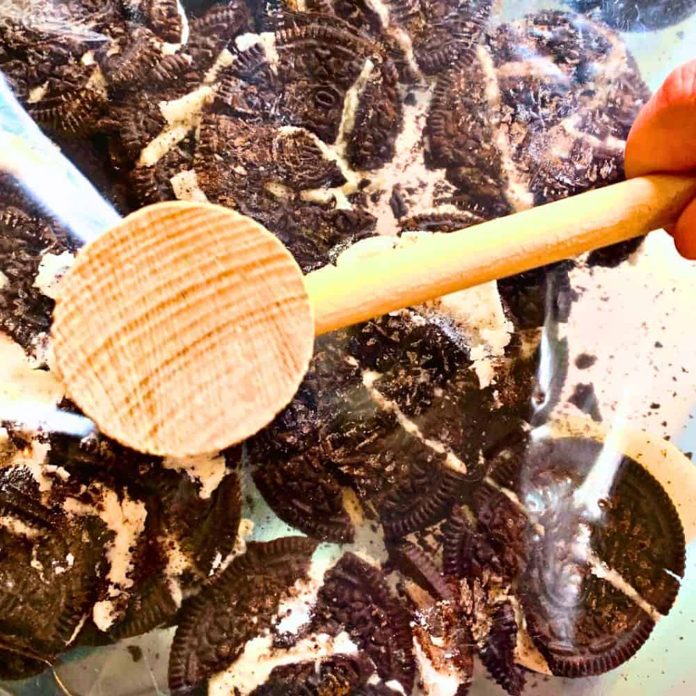 How To Make Grinch Poop Recipe Step By Step Crush Oreos - crushing oreo cookies inside a bag with a wooden mallet