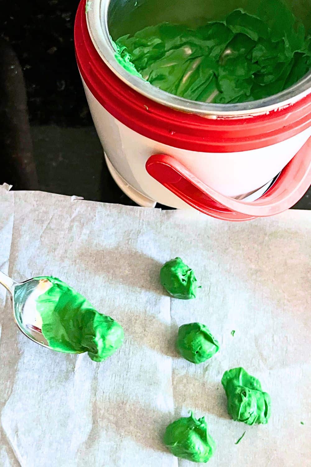 Melt your Grinch green chocolate for Grinch Poo - Grinch Poo candies on parchment paper