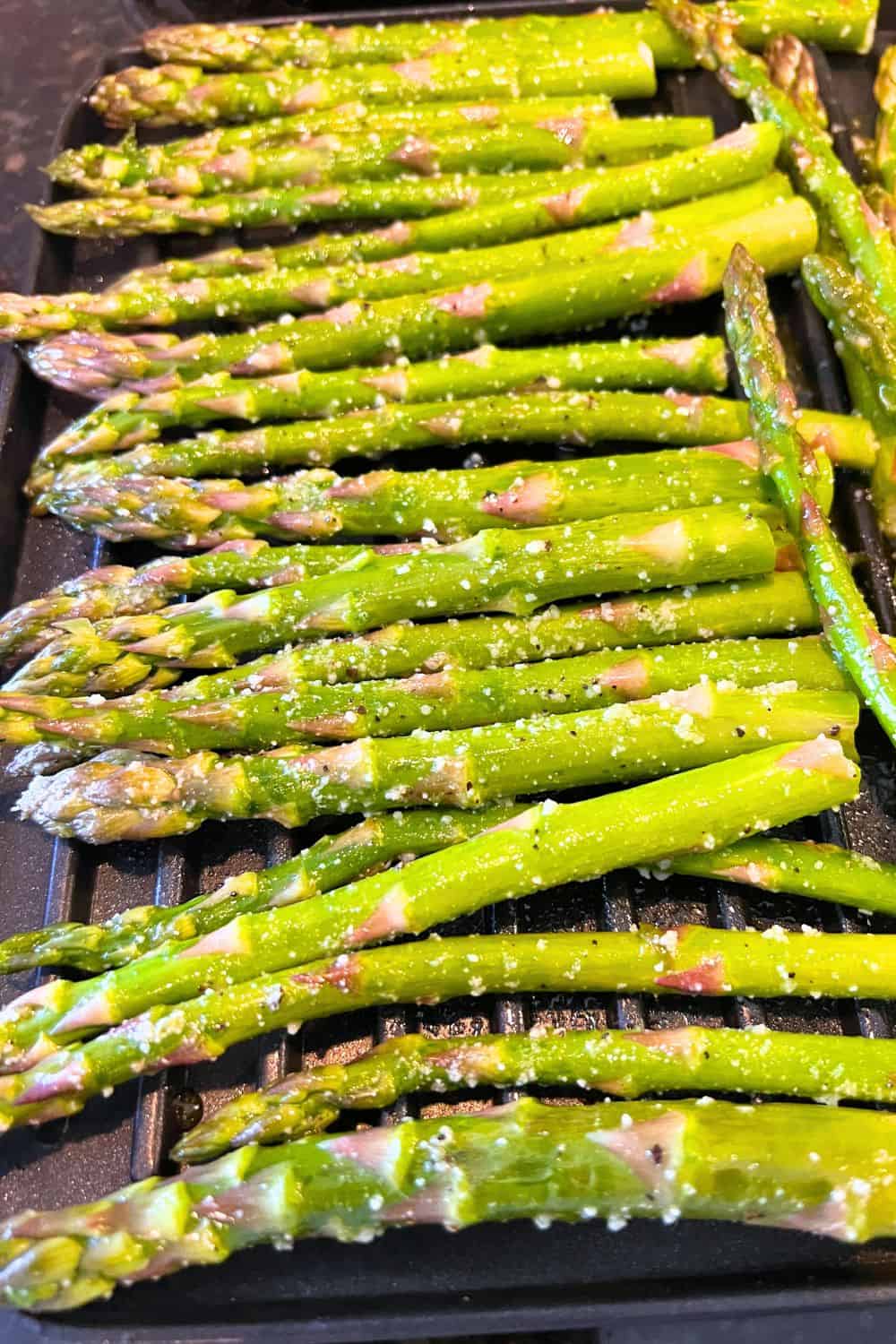 Best Air Fryer Roasted Asparagus Recipe with single layer of air fried asparagus on an air fryer oven baking sheet