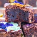 Dark Chocolate Brownies With Edible Flowers stacked on each other