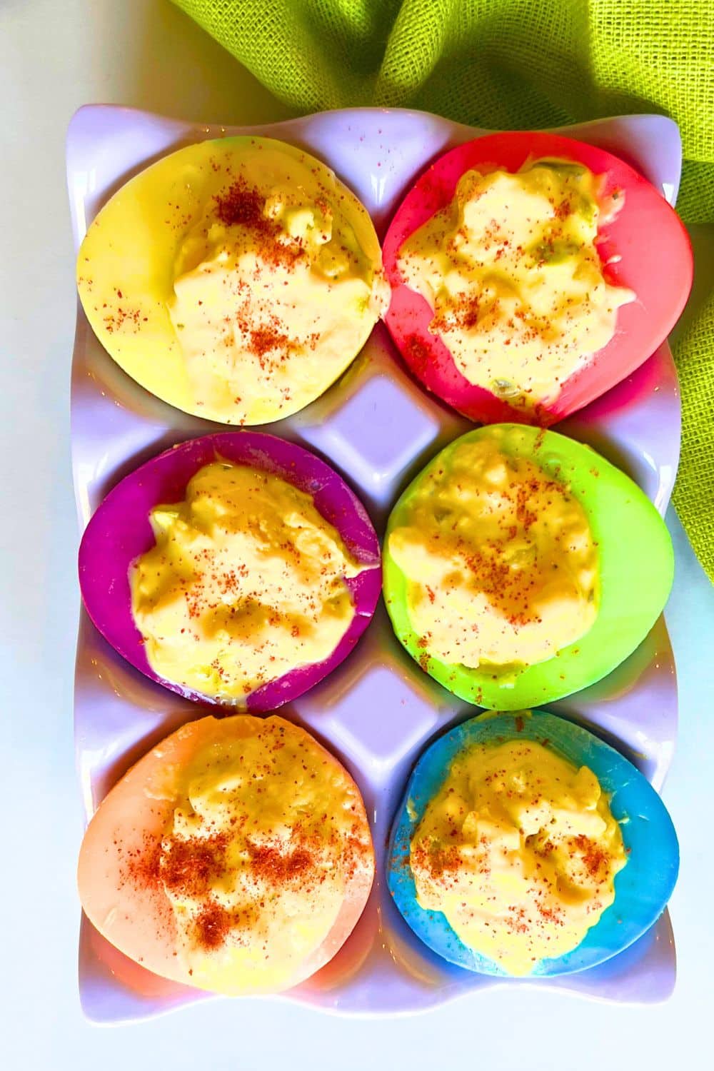 Dyed Deviled Eggs - different colored eggs whites filled with devil egg filling on a table