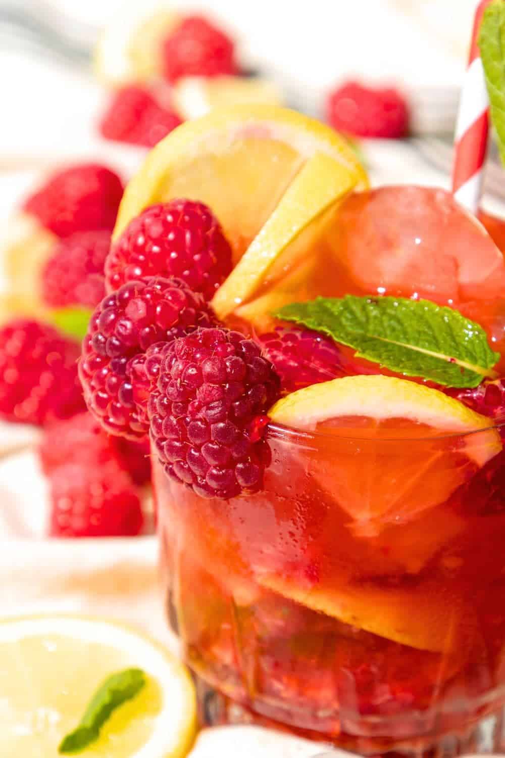 Sparkling Lemon Raspberry Punch on a table with fresh raspberries and fresh lemons