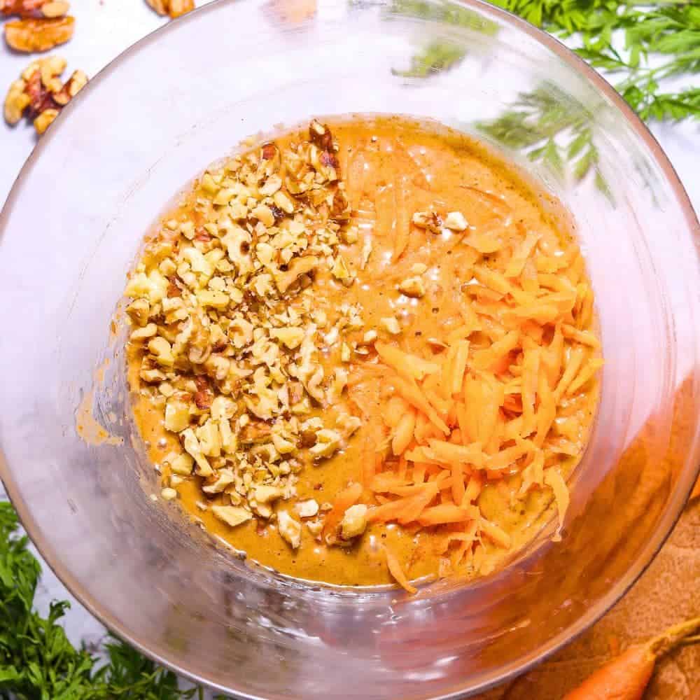 Using Boxed Cake Mixes To Make Homemade Cakes With Carrots - carrot cake mix in a bowl with real shredded carrots and chopped walnuts