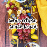 Solar Eclipse Snack Board Ideas text over top down view of solar eclipse party dessert board on a party table