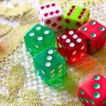 Dice Christmas Gift Exchange Game - green dice, red dice and white game dice on a lacy green christmas tablecloth