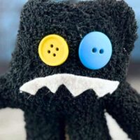 Easy Monster Halloween Crafts For Kids - friendly monster craft made from a child's black glove with a funny face made of button eyes and felt mouth