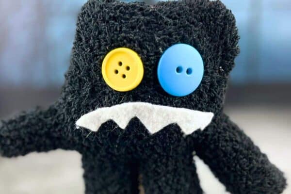 Easy Monster Halloween Crafts For Kids - friendly monster craft made from a child's black glove with a funny face made of button eyes and felt mouth