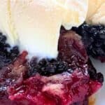 Homemade Blackberry Cobbler Recipe in a white bowl with vanilla ice cream on top