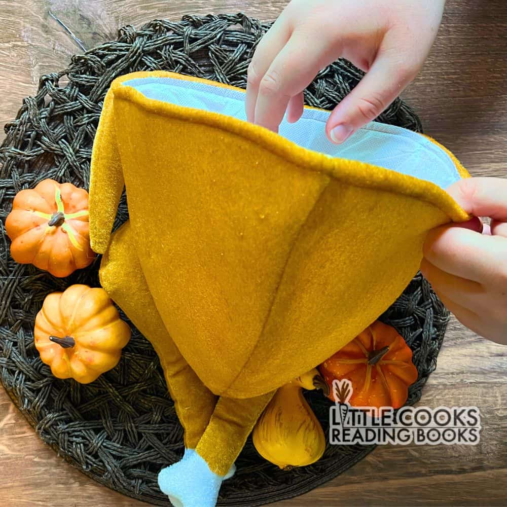 Funny Fall Games For Kids and Adults - hand playing the turkey stuffing game for Thanksgiving games