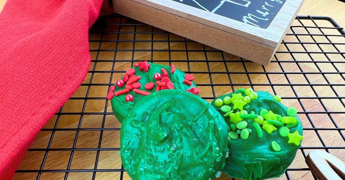 Chocolate Covered Oreos Christmas Cookies - Dipped Christmas Oreos Are the perfect holiday treat - Green Chocolate Dipped Christmas Oreos on a cooling rack with a red Christmas napkin for Christmas Food Desserts Classic Cookies