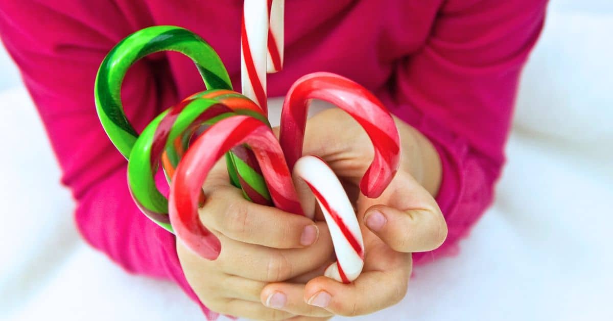 Candy Cane Games for Christmas Party - child holding different colors candy canes for Christmas Party Games For Groups, teen games or kids Christmas games