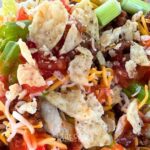 classic taco salad recipe with tortilla chips and salsa in a white salad bowl