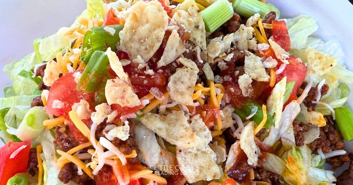 classic taco salad recipe with tortilla chips and salsa in a white salad bowl