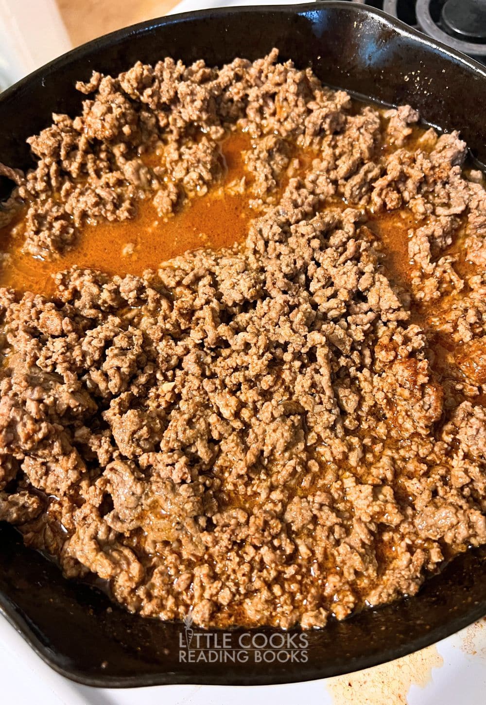 taco ground beef in cast iron pan on stove for a homemade taco salad recipe