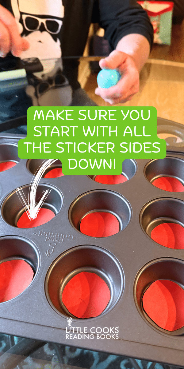 Christmas party guest tossing a ping pong ball into a Christmas muffin tin