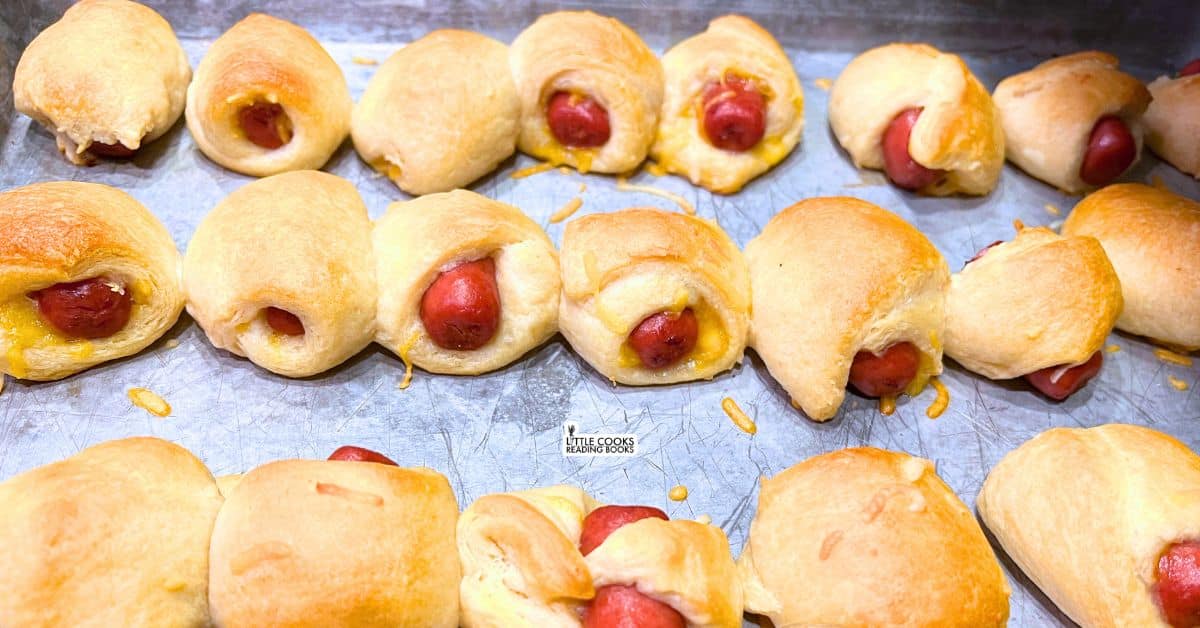 Cheesy Mini Pigs In A Blanket Party Bites on a baking sheet for party appetizers snacks - real recipes from Little Cooks Reading Books