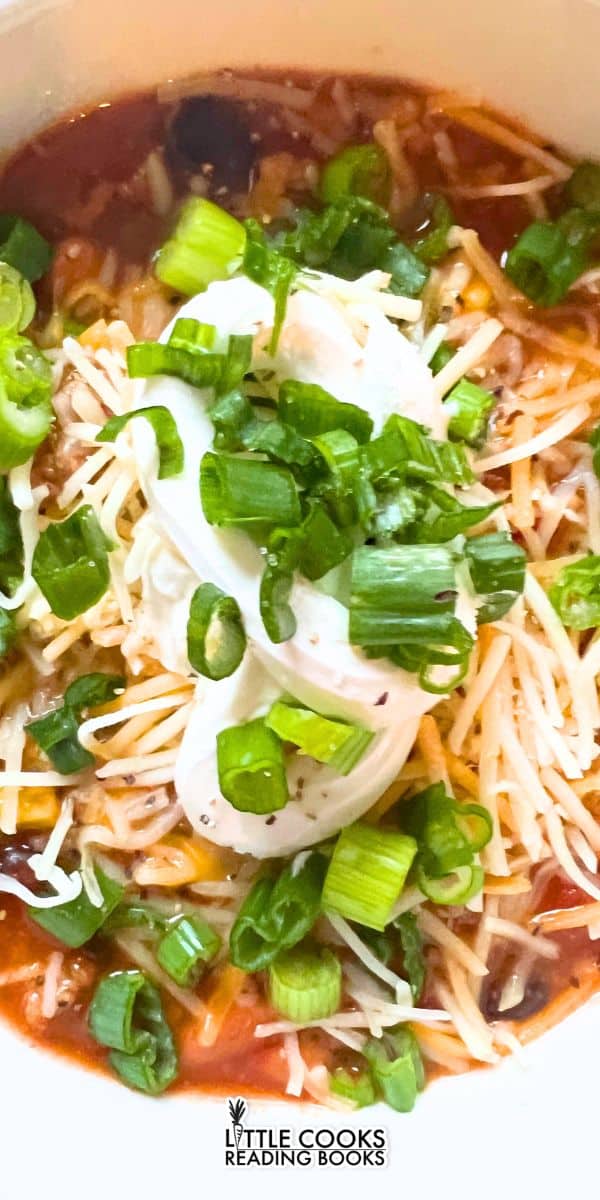 top down view of homemade taco soup comfort foods with soup toppings in a white bowl