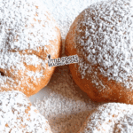 fake beignets recipe made with biscuits and powdered sugar on a plate