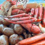 seafood boil party with crab legs, potatoes, shrimp and corn on a seafood platter in front of water